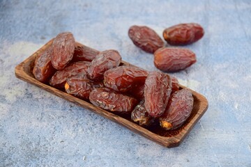 Fresh raw organic Medjool dates on blue background