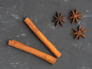 Star anise, cinnamon on black concrete background