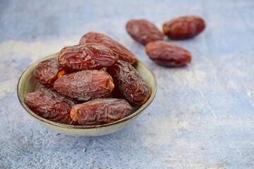 Fresh raw organic Medjool dates on blue background, selective focus