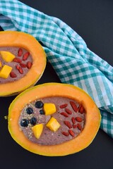 Melon bowl with berry smoothie topped with goji berry, mango, blueberry and hemp seeds
