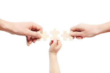 Three hands are holding puzzles on a white background. Help of a psychologist in family problems.