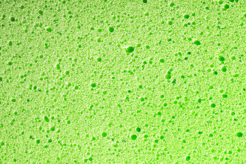 Sponge background. Closeup sponge texture. Green porous foam structure. Plastic air bubble holes texture.