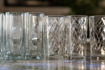 Empty clean glass goblets stand on table against dark background 