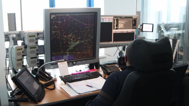 Navigation control room in the airport - a man working with a monitor with fly paths placed on the map