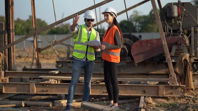 architect man and foreman women discuss with plan in paper work on construction site at village . contractor worker Inspection with builder . Engineer training Quality control in Residence industry