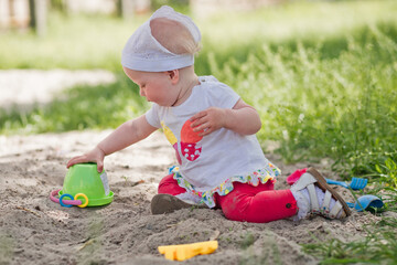 little girl in sandbox with shovels and bucket at playground. child in panama in summer on street....