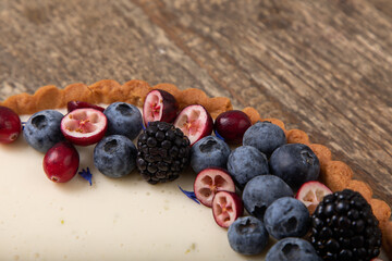 Panna cotta tart with fresh berries on wooden table