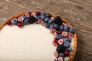 Panna cotta tart with fresh berries on wooden table
