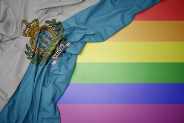 waving national flag of san marino on a gay rainbow flag background.