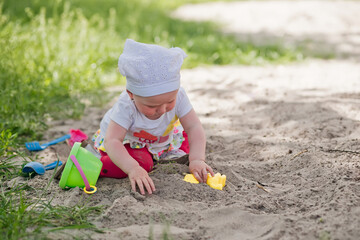 little girl in sandbox with shovels and bucket at playground. child in panama in summer on street....