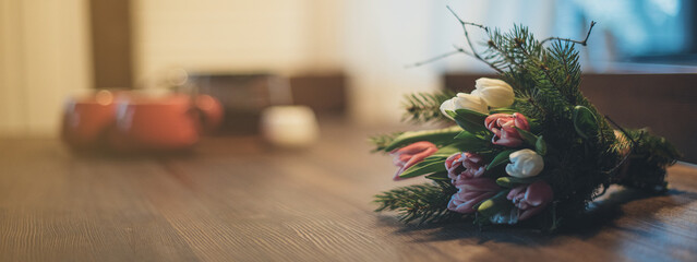 Spring bouquet of tulips lies on the table in the evening. March 8