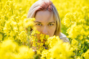 Young woman stands in a rape field