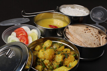 Typical Stainless steel Lunch Box or Tiffin with Maharashtrian food menu Chapati OR Roti, Plain Dal...