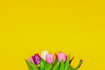 Bouquet of flowers on a yellow background. Congratulations on the holiday, March 8, Valentine's Day or birthday. Multicolored tulips