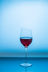 Close up view of red wine in glass isolated on blue background. 
