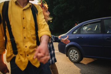 A man and a woman are hitchhiking. A young couple goes hitchhiking around the country. Free hitchhiking trip. A lover who travels free by hitchhiking. The couple goes traveling. Couple by the road