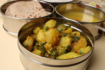Typical Stainless steel Lunch Box or Tiffin with Maharashtrian food menu Chapati OR Roti, Plain Dal Tadka, White Rice Potato sabji with salad and pickle