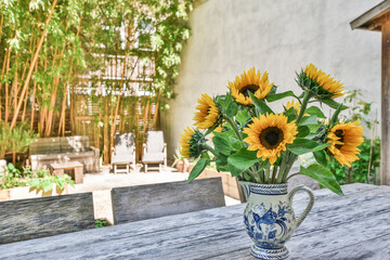 Close-up of a vase of beautiful sunflowers on the table at the backyard of the house © Casa imágenes