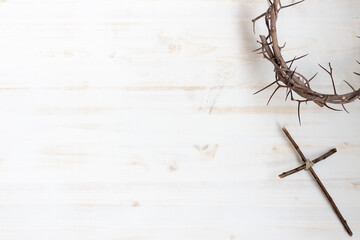 Crown of thorns and cross on white wood background with copy space