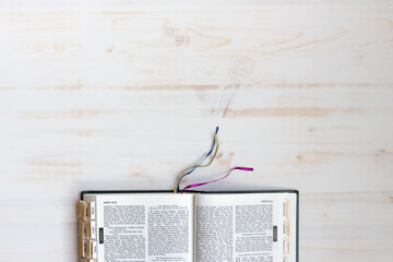 open bible on white wood background from above
