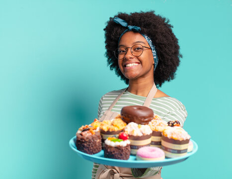 young pretty afro woman baker with cakes