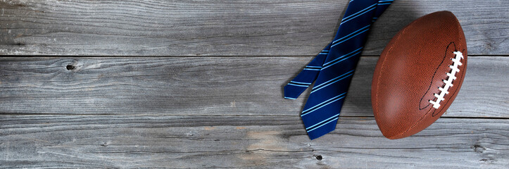 Blue striped tie plus football on weathered wooden planks for Happy Fathers Day