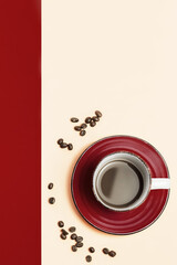 Top view of coffee cup with coffee and coffee beans on red and beige background. Color block, concept for background advertising with copy space.