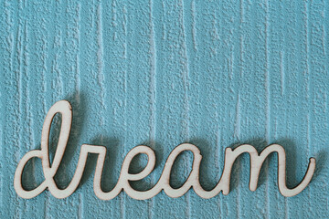 Mot dream écrit en bois sur un fond bleu vintage