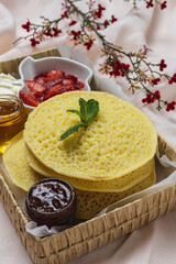 Homemade traditional moroccan baghrir with honey, strawberries and mint from above