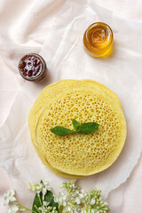 Homemade traditional moroccan baghrir with honey, strawberries and mint from above