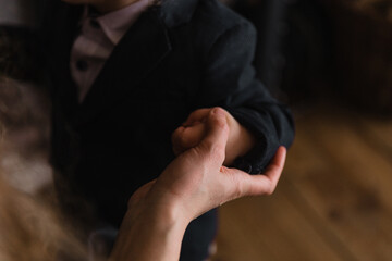 Mom holds her little son by the hand