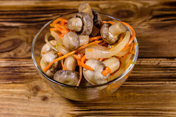 Canned mushrooms with carrot and onion in a ceramic bowl