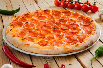 Fresh baked pepperoni pizza on the wooden background