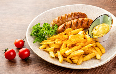 German fried sausages with French fries and mustard sauce. 