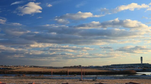 A commercial passenger airplane takes off from Ronald Reagan Washington National Airport in Arlington, Virginia near Washington, D.C. on an evening in the winter. The sky is full of cumulus clouds. 