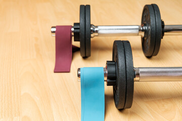 Dumbbells and elastic bands on the floor at home. Keeping fit during lockdown. Fitness equipment for strength training 