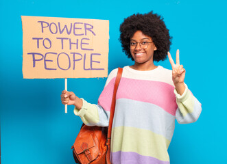 young pretty afro woman protesting with  a power to the people banner