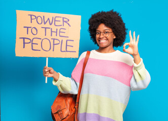 young pretty afro woman protesting with  a power to the people banner