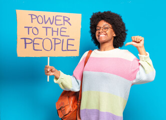 young pretty afro woman protesting with  a power to the people banner