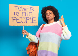 young pretty afro woman protesting with  a power to the people banner