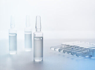 Ampoules from transparent glass on light defocusable background. Selective focus. Copy space