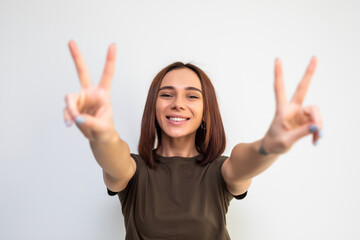 cheerful smiling woman going crazy on white background showing peace sign