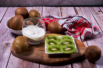 Yoghurt glass and plate of cut kiwis