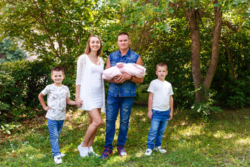 Fototapeta premium Happy family with newborn baby on natural green background