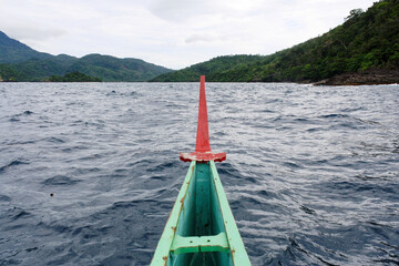 View from an Indonesian traditional fishing boat in sea with hill in background at Kiluan Bay, Lampung Province, Indonesia.