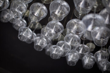 Empty wine glasses hanging up side down on black background.