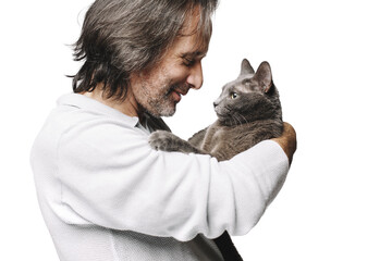 an adult man holding a gray cat in his arms. They're happy. The background is isolated.