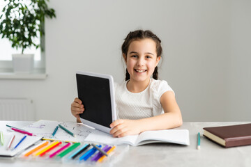 Cute little girl studying at home and smiling