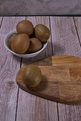 Kiwis in white bowl and wooden board