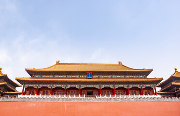 Beijing, China - April 27, 2010: Forbidden City. Meridain Gate seen over red wall under blue sky. Chinese architecture with reds and orange. One Blue spot.